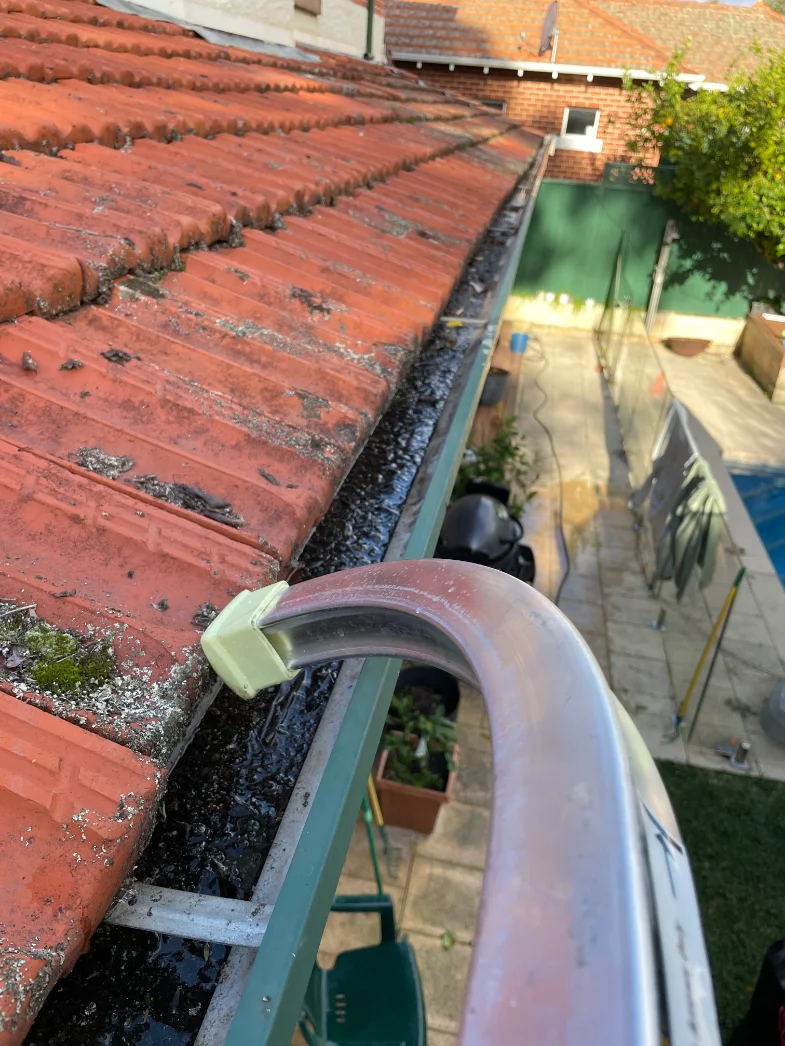 Two-storey tiled roof gutters before cleaning