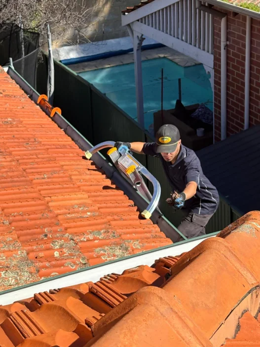 Gutter being cleaned by hand